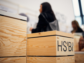 Messestand der HSBI, im Hintergrund steht eine Person