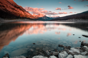 Das Bild zeigt einen See in Kanada in dem sich die Berglandschaft spiegelt.