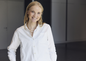Ein Porträt von Kristin Maoro. Sie trägt eine weiße Bluse und hat blonde Haare.