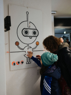 Ein Kind agiert mit der Roboter-Installation