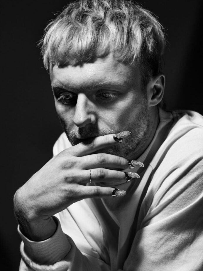 Mann mit langen, lackierten Fingernägeln