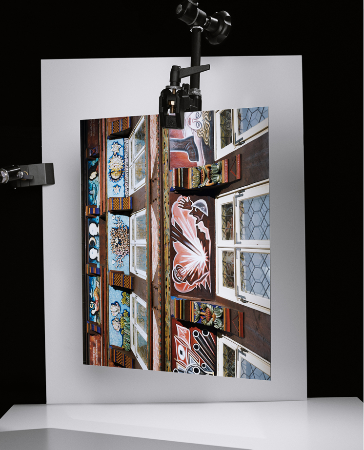 Ein Foto und ein weißes Papier, die mit Halteklemmen voreinander gehalten werden