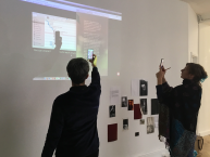 Teilnehmer mit Smatphones vor Projektion