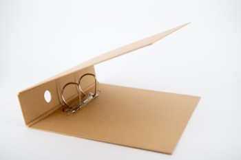 Nachhaltiger Aktenordner liegt leer und halb geöffnet auf einem Tisch