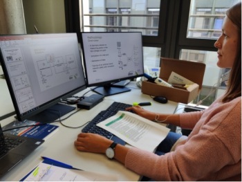 Frau sitzt am Computerarbeitsplatz