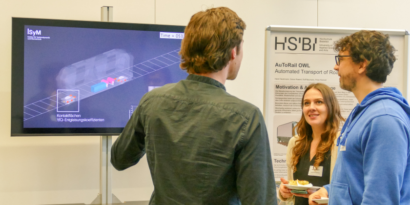 Forschende der HSBI diskutieren den Fortschritt an der Fahwerkssimulation des MONOCAB.