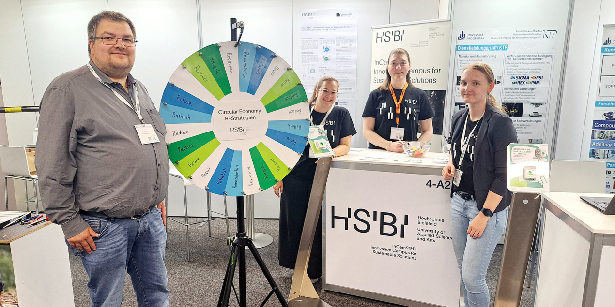 Vier Personen stehen an einem Messestand auf der Kunststofftechnik Nord