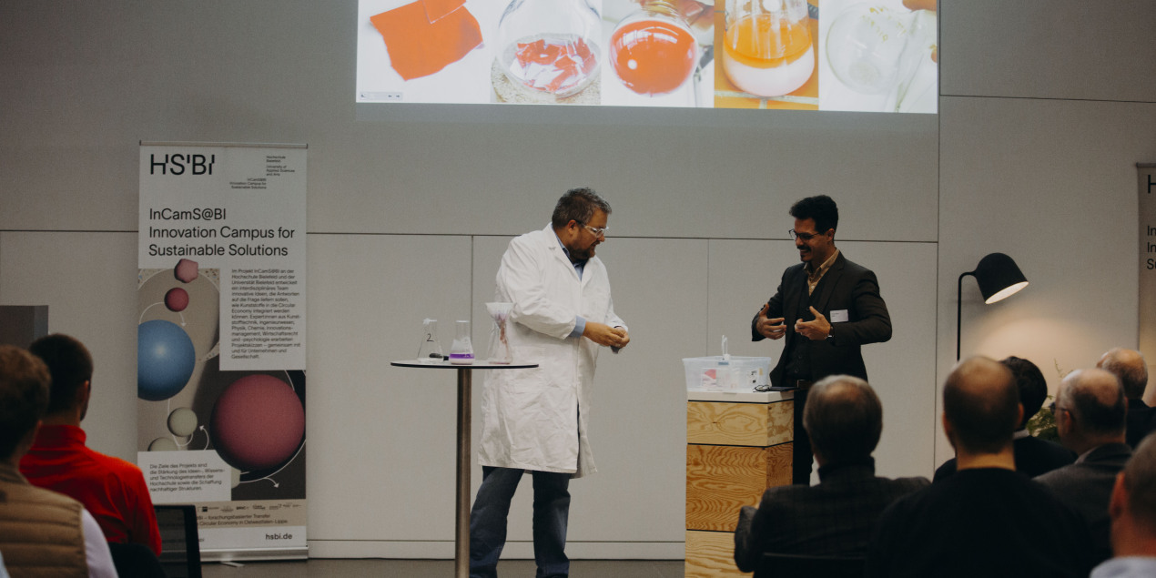 Matthias Pieper steht im Laborkittel auf einer Bühne