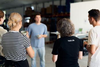 Fünf Personen stehen im Kreis und unterhalten sich.