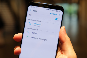 Eine Hand hält ein Handy. Auf dem Display wird die Verbindung zum BiFree angezeigt.