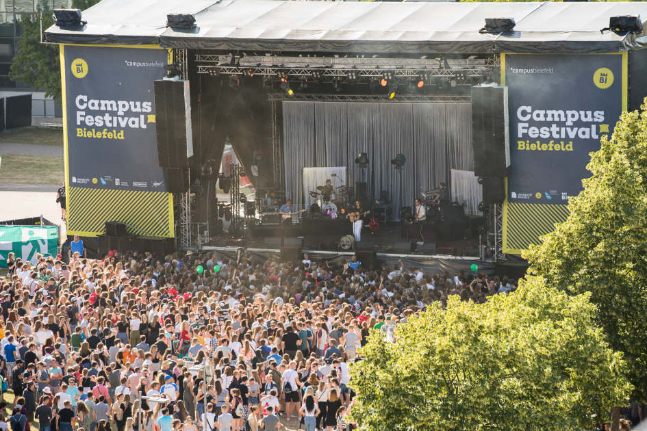 Eine Menschenmenge steht vor einer Bühne