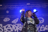 Eine Frau mit Mikro in der Hand auf einer Bühne