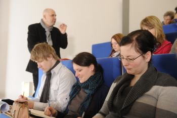 Dozent mit Studierenden im Hörsaal