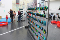 Bauzaun mit Broschüren als Teil einer Ausstellung.