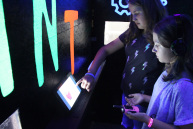 Zwei Mädchen in einem bunt beleuchteten Raum