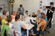 Eine Person erklärt einer Gruppe von Kindern etwas