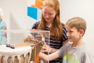 Zwei Kinder schauen sich ein Exponat der Ausstellung an