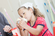 Ein Mädchen bastelt mit Spaghetti und Klebeband