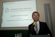 Herr Pinkwart begrüßt am Mikrofon vor einer PPP die anwesenden Gäste