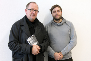 Zwei Männer, eine rhält das Buch \