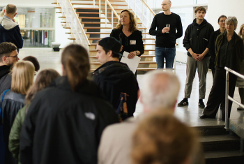 Eine Frau steht auf einer Treppe vor Menschen