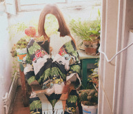 Eine abstrahiertes Porträt einer Frau die auf einem Balkon zwischen Pflanzen sitzt das Gesicht erkennt man nicht