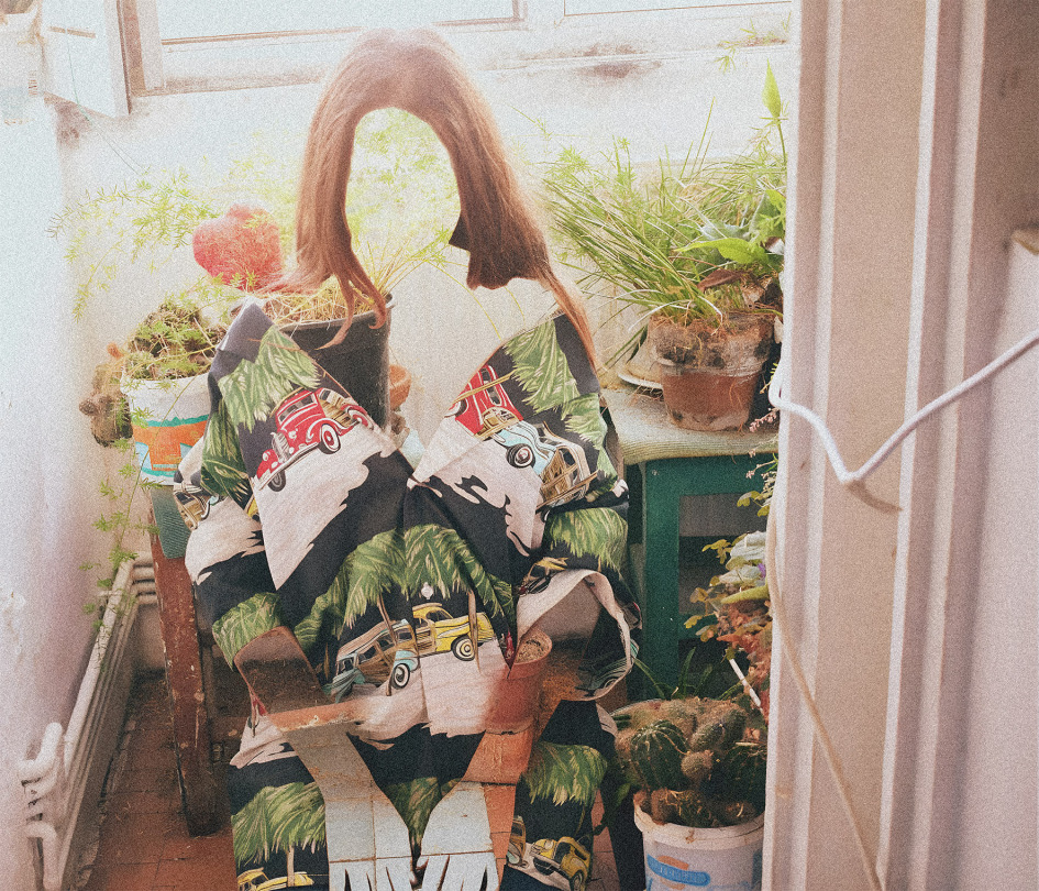 Eine abstrahiertes Porträt einer Frau die auf einem Balkon zwischen Pflanzen sitzt das Gesicht erkennt man nicht