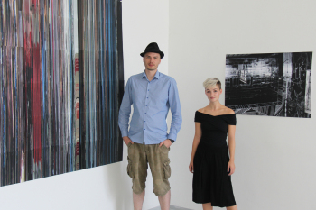 Ricarda Treppner und Robert Krischan stehen vor ihren Arbeiten, die an der Wand hängen und die sie in Erfurt ausstellen.