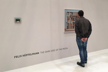 Mann steht vor Bild in der Ausstellung