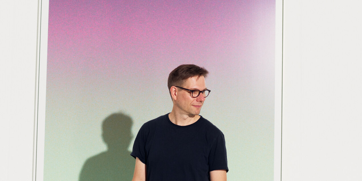 Porträt Prof. Sauer vor Bild in lila und grün