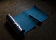 Ein Foto von einer halb ausgerollten Gymnasiktmatte mit einem Riss