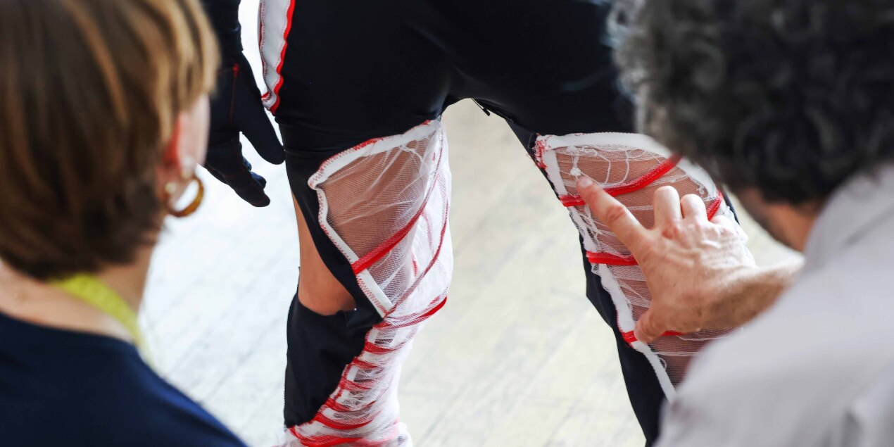 Ein Kostüm in Nahaufnahme Eine schwarze Eishockey-Hose ist mit Einsätzen aus weißem Tüll und roten Bändern ausgestattet