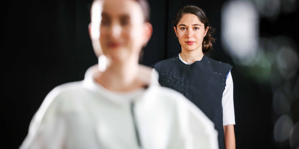 Zwei Tänzerinnen stehen im Scheinwerferlicht