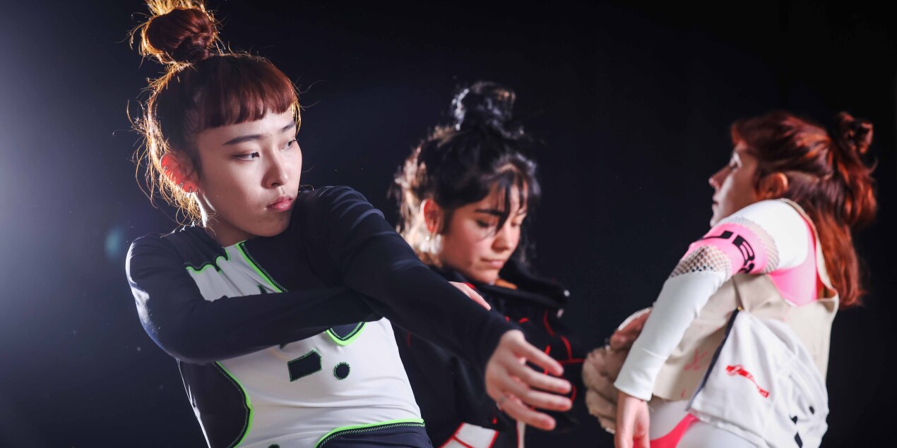 Drei Frauen tanzen im Scheinwerferlicht