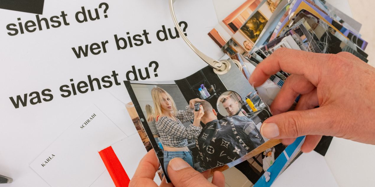 Hände halten die Fotografien von Karla Schradi