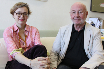 Prof. Dr. Anna Zika und Karl Martin Holzhäuser sitzen auf einem weißen Sofa.
