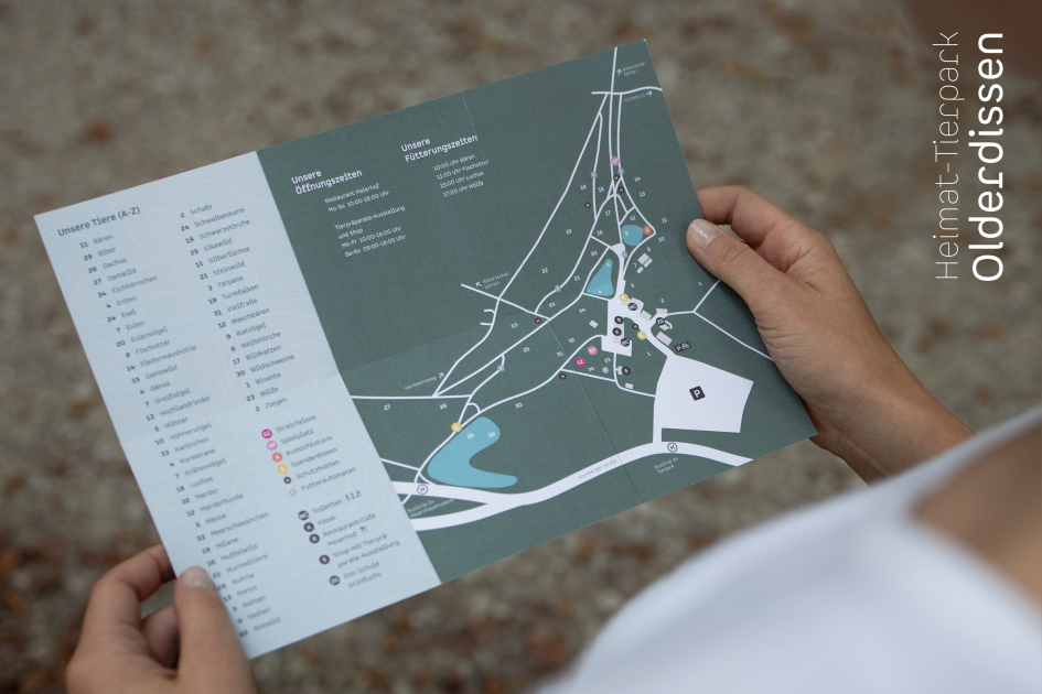 Zwei Hände halten einen Übersichtsplan des Tierparks Olderdissen