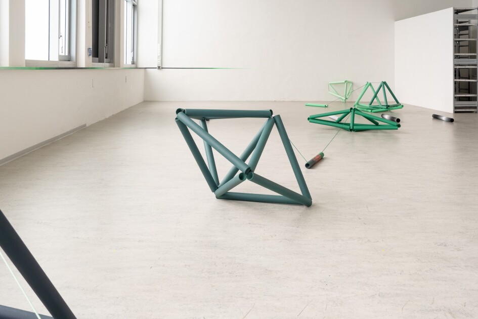 Auf dem Boden sind dreidimensionale Formen aus Rohren angeordnet.