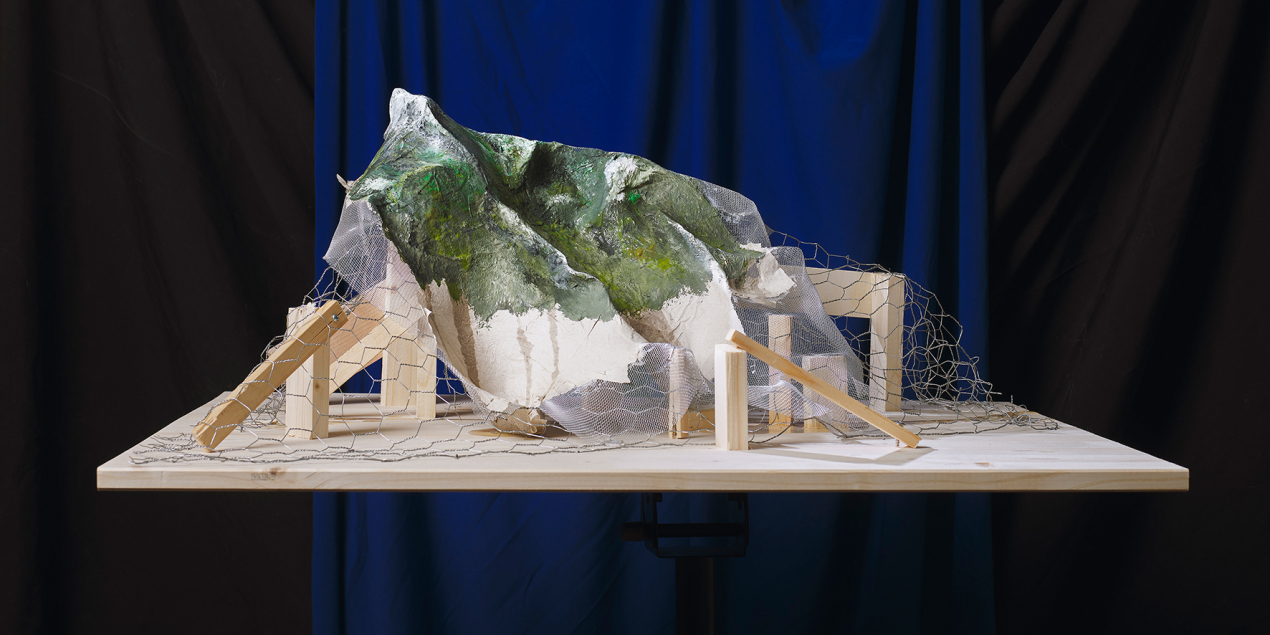 Eine Konstruktion von Holz und Papier steht auf einem Holzbrett