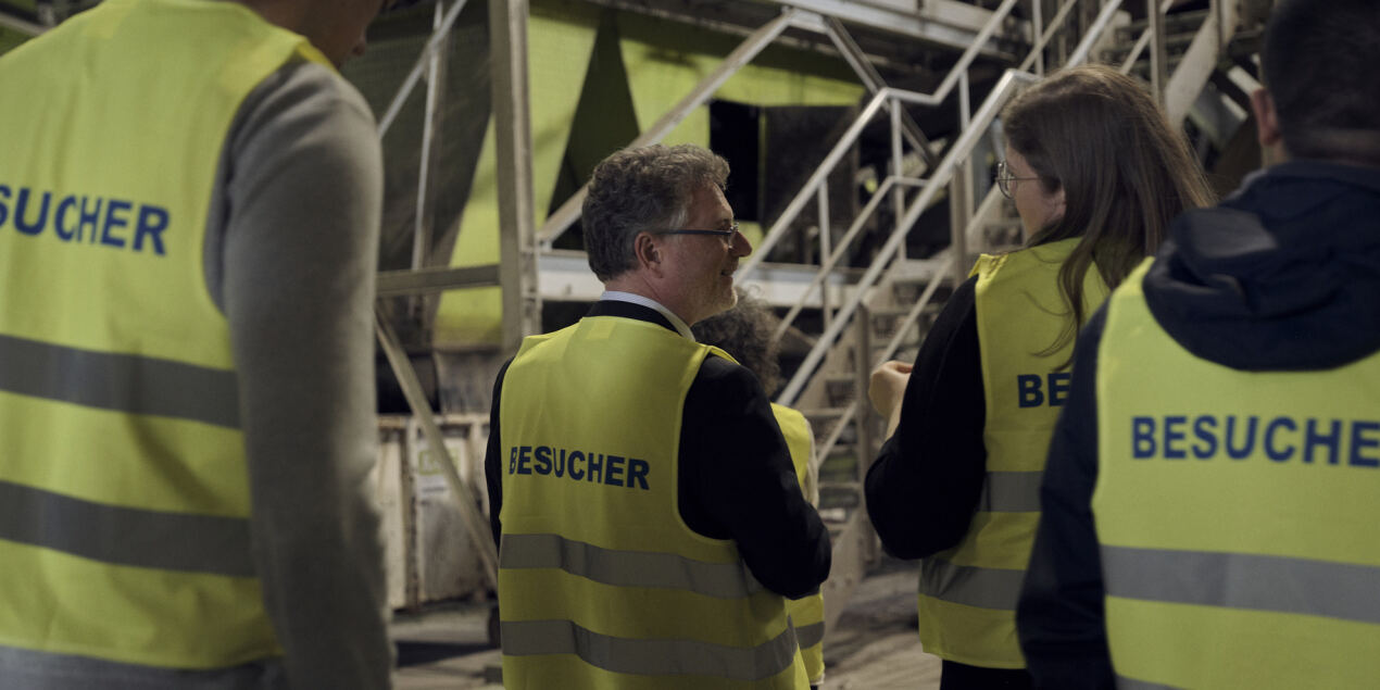 Bild der Besuchsgruppe während des Rundgangs durch die Halle der abfallbehandlungsanlage