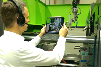 Mit einem Tablet filmt Prof. Dr. Daniel Paßmann, was in der Spritzgießmaschine passiert.