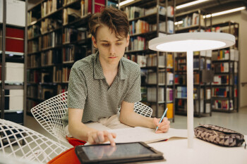 Foto: Nico Niesterok arbeitet in der Bibliothel des Campus Minden an einem Tablet