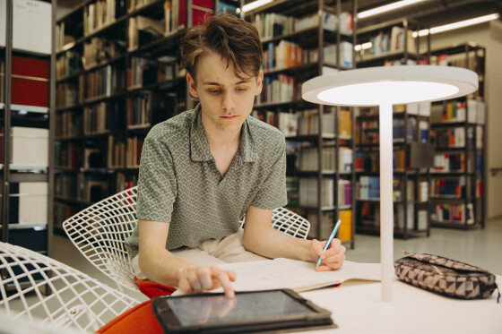 Foto: Nico Niesterok arbeitet in der Bibliothel des Campus Minden an einem Tablet
