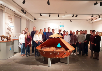 Gruppe studierender stehthinter einem Objekt