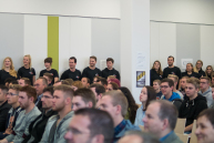 Einige Personen stehen an einer Wand in der Mensa