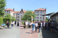 Personen stehen vor dem Hörsaalgebäude