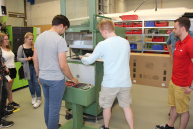 In der Maschinenhalle legt ein Student etwas in die Tiefziehmaschine