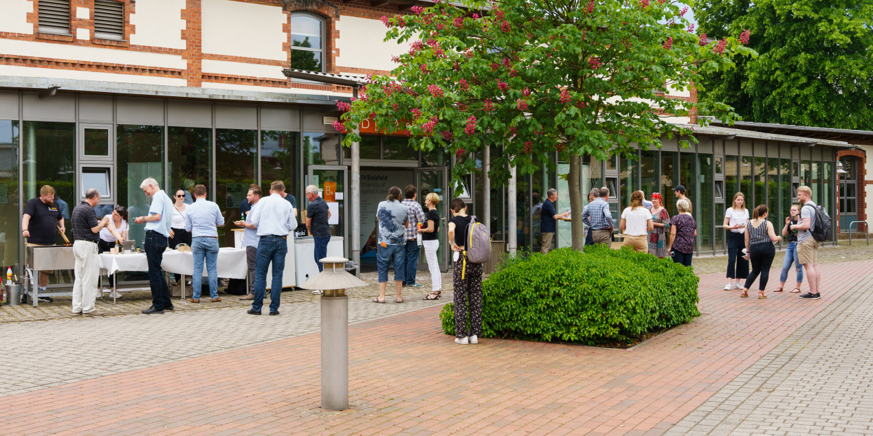 Vor dem Hörsaalgebäude stehen einige Menschen