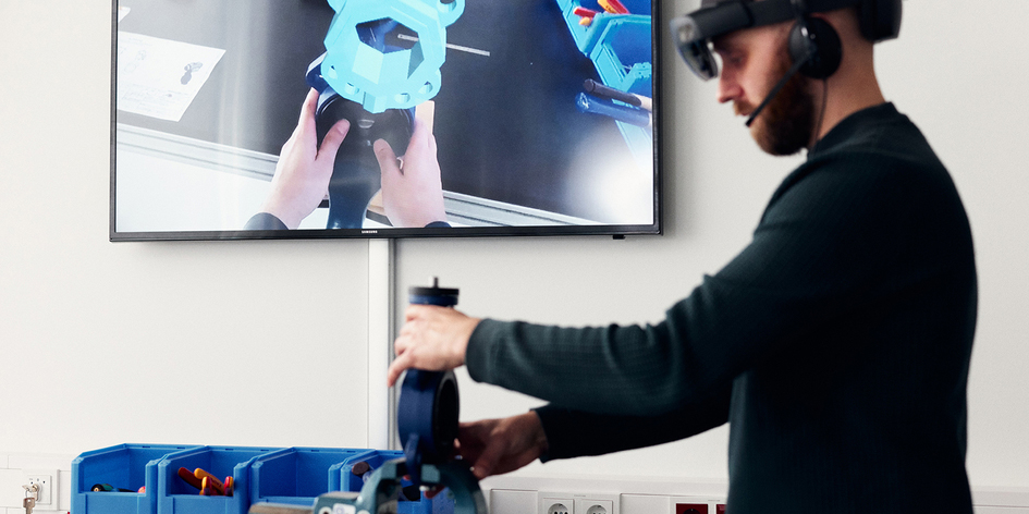 EiN mann mit VR Brille bedient einen Schraubstock