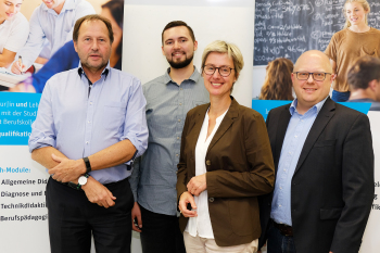 Vier Personen stehen vor einer Tafel.